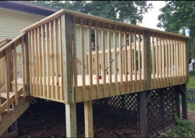 Partially constructed backyard deck in Berlin, CT, showing framing and support beams in progress during the deck building process.