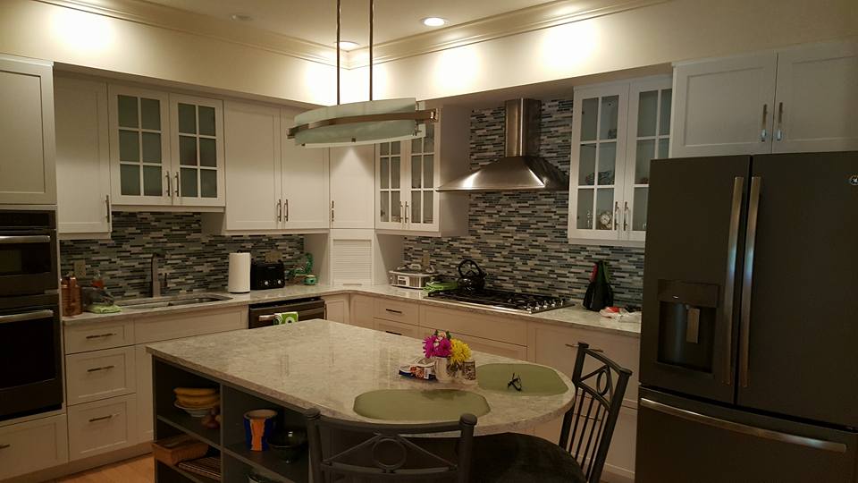 Newington Kitchen dark wood Contemporary kitchen remodel featuring white shaker cabinets with glass inserts, stainless steel appliances, mosaic tile backsplash, granite countertops, and center island with built-in shelving — Central Connecticut Building and Remodeling, Newington, CT.